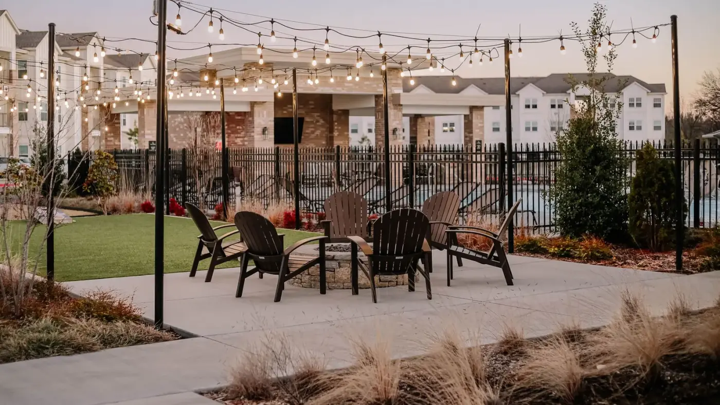 An outdoor kitchen and patio entertaining area at dusk, the kind of full-backyard scope Larkspur designs and builds